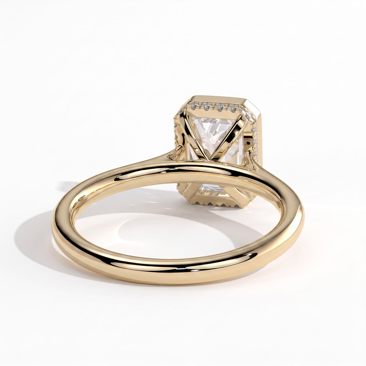 Emerald lab-grown diamond bezel-set halo engagement ring in 18K (750) yellow gold, on white background 