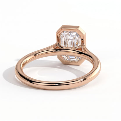 Emerald lab-grown diamond bezel-set solitaire engagement ring in 18K (750) rose gold, on white background 