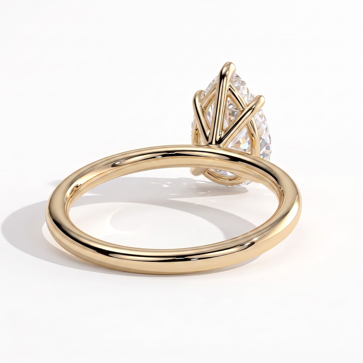 Pear lab-grown diamond solitaire engagement ring in 14K (585) yellow gold, on white background 