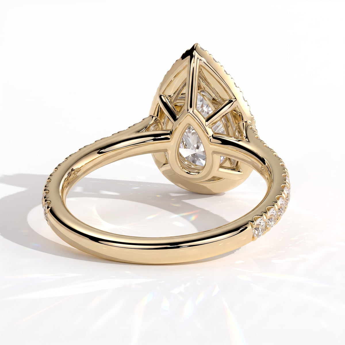 Pear lab-grown diamond halo engagement ring in 14K (585) yellow gold, on white background 