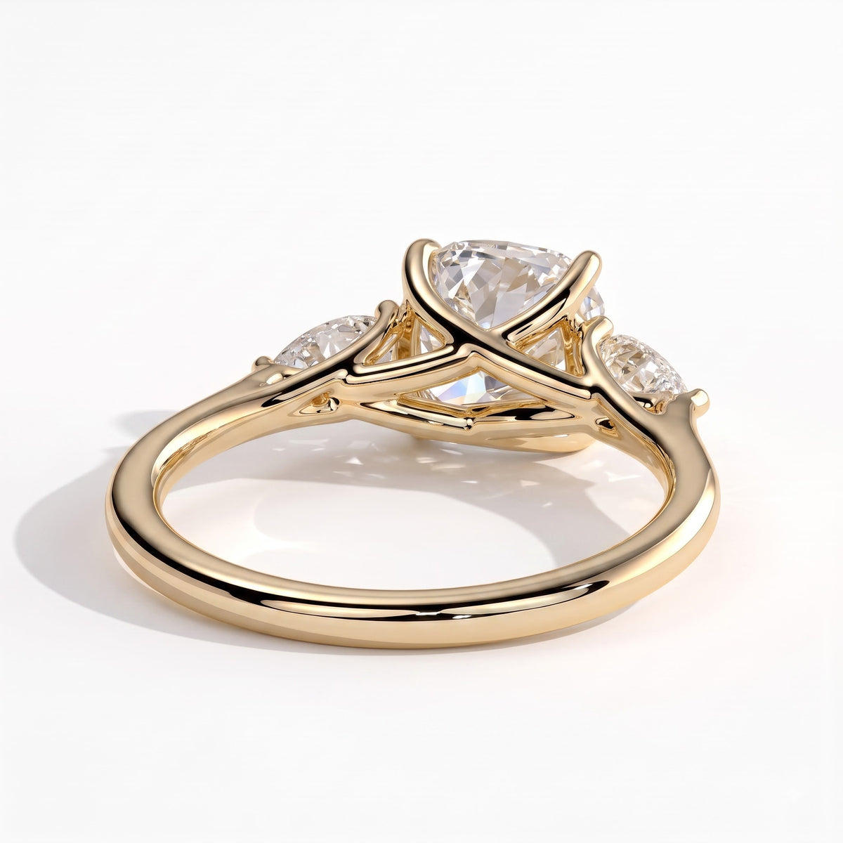 Cushion lab-grown diamond three-stone engagement ring in 14K (585) yellow gold, on white background 