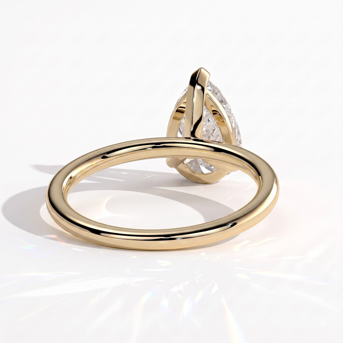 Pear lab-grown diamond solitaire engagement ring in 18K (750) yellow gold, on white background 