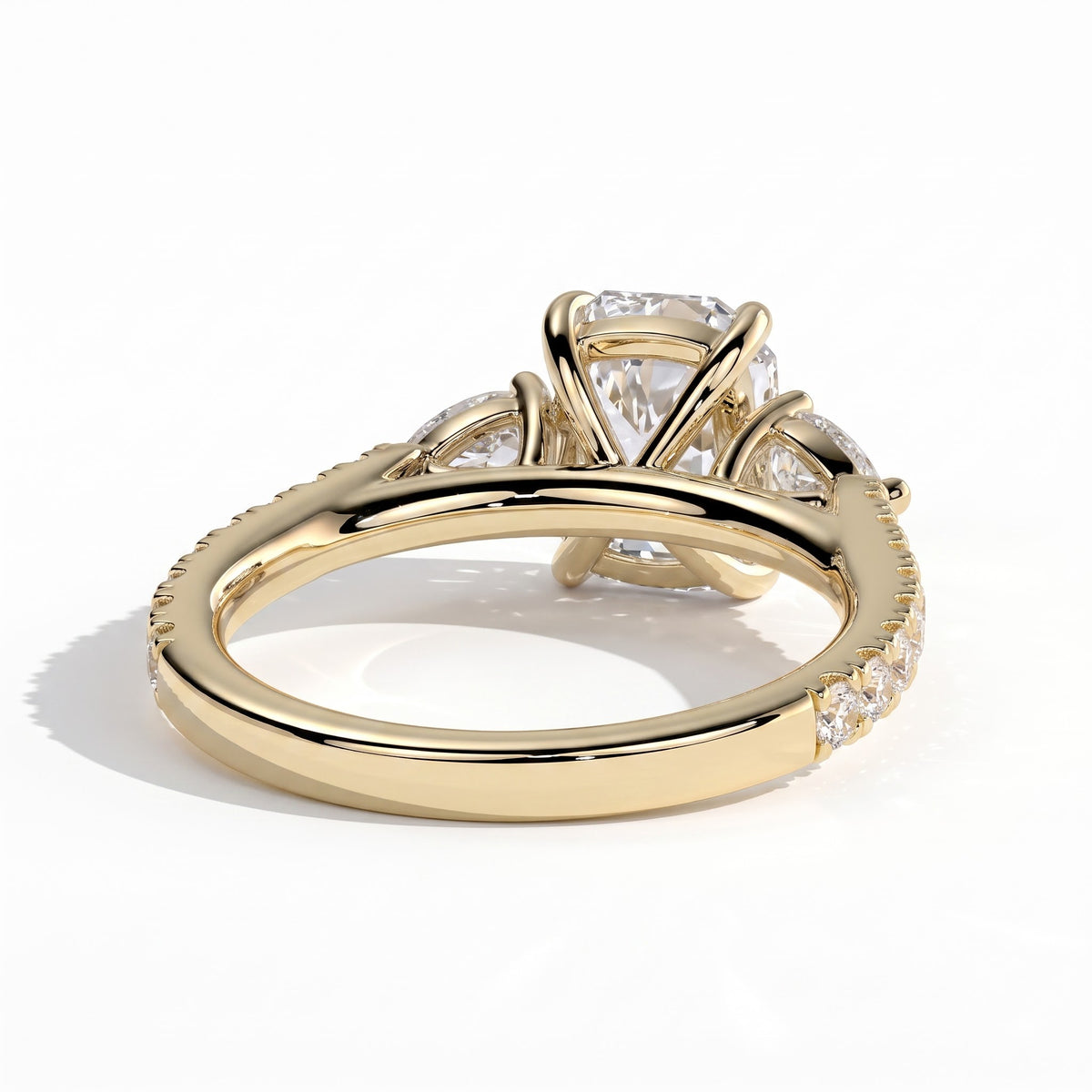 Elongated Cushion lab-grown diamond three-stone engagement ring in 18K (750) yellow gold, on white background 