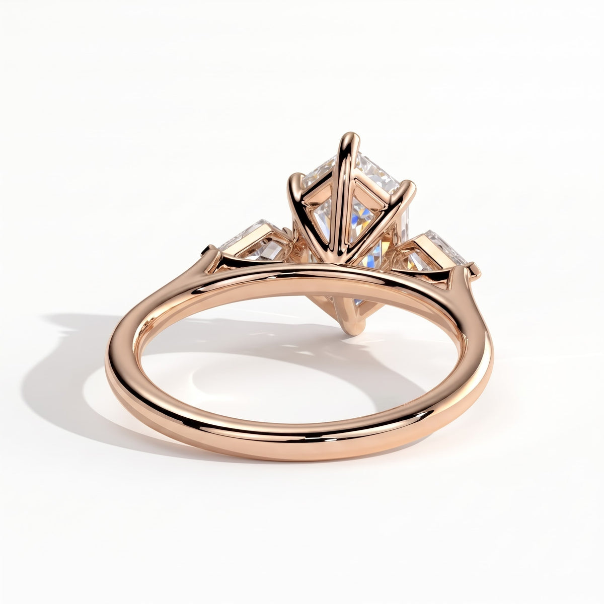 Elongated Hexagon lab-grown diamond three-stone engagement ring in 18K (750) rose gold, on white background 
