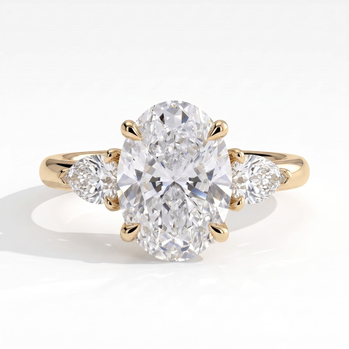 Oval lab-grown diamond three-stone engagement ring in 18K (750) yellow gold, front view 