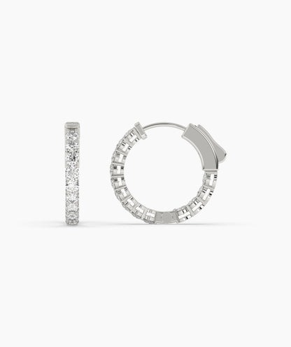 Silver hoop earrings with clear gemstones on a white background. 