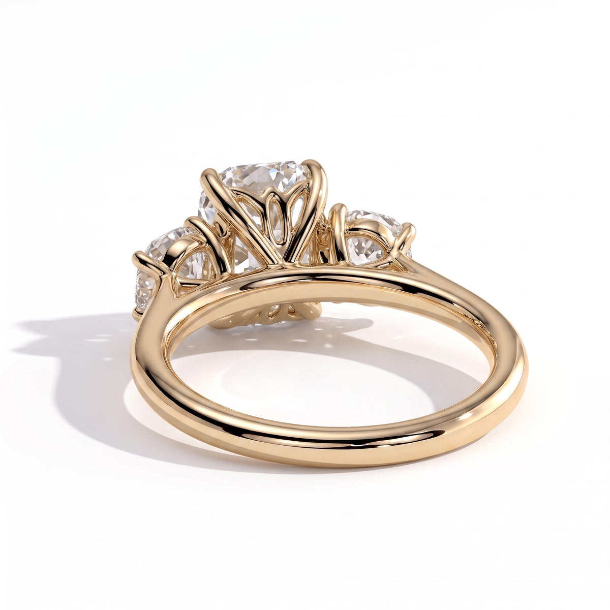 Elongated Cushion lab-grown diamond three-stone engagement ring in 18K (750) yellow gold, on white background 