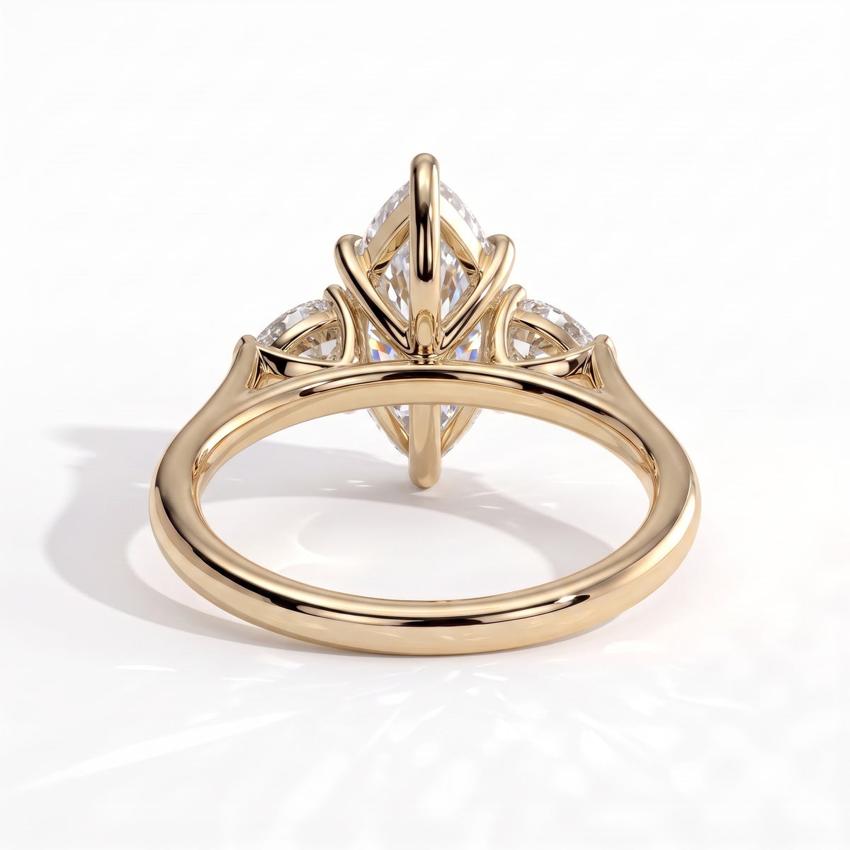 Marquise lab-grown diamond three-stone engagement ring in 14K (585) yellow gold, on white background 