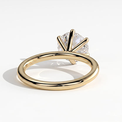 A yellow gold solitaire ring with a round brilliant-cut diamond, shown on a clean white background with a soft shadow. 