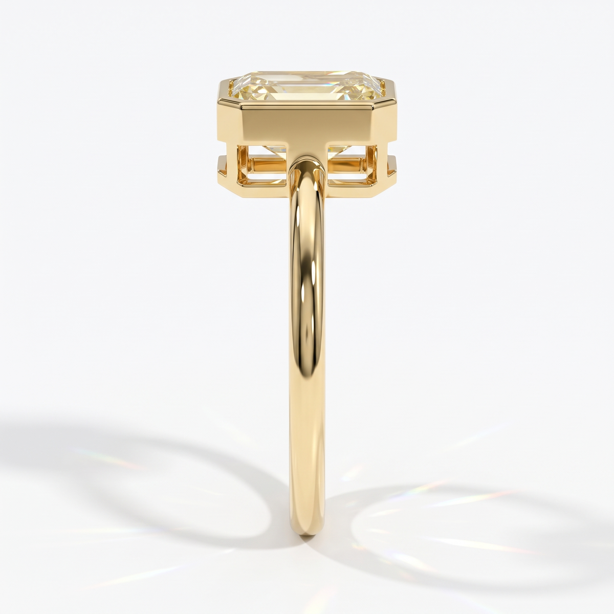 Fancy Intense Yellow emerald cut lab-grown diamond bezel ring in 14K (585) yellow gold, side profile 