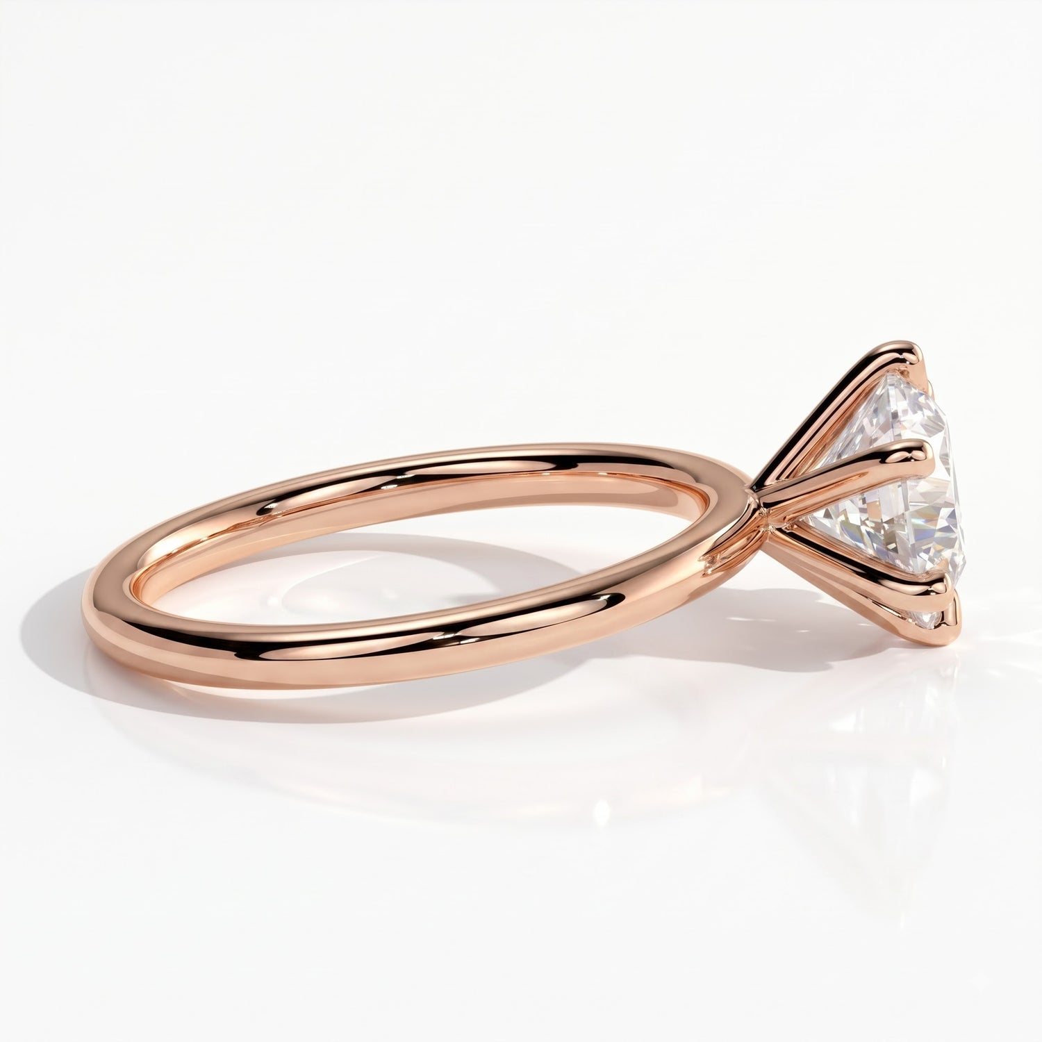 A rose gold engagement ring featuring a large round brilliant-cut diamond, shown in a three-quarter side view on a clean white background. 