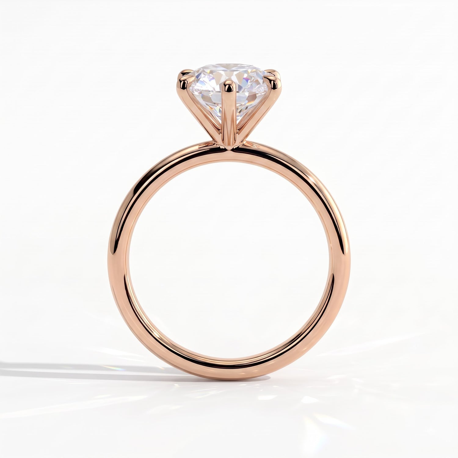 A rose gold solitaire engagement ring with a round brilliant-cut diamond, shown from a front-facing perspective on a clean white background. 