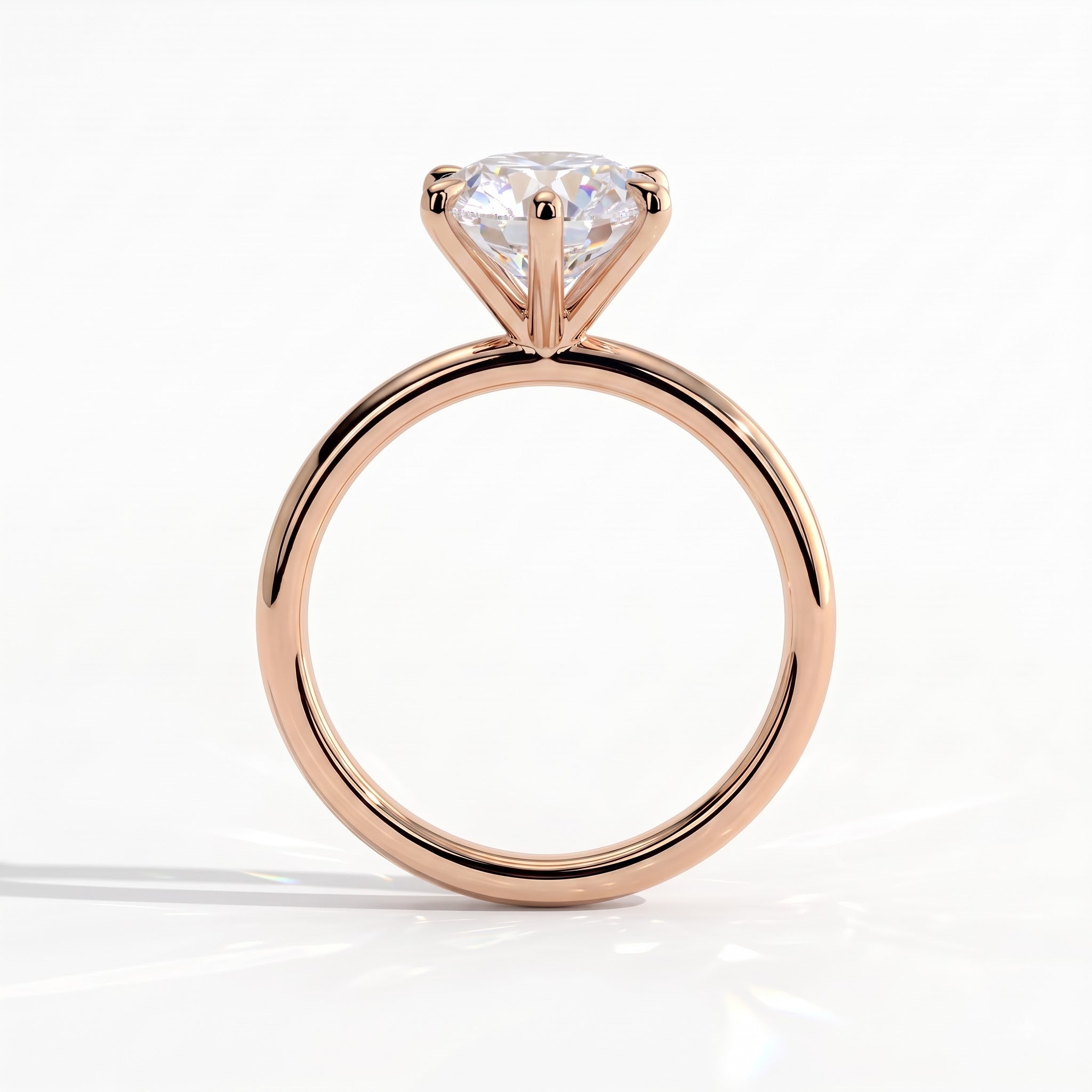 A rose gold solitaire engagement ring with a round brilliant-cut diamond, shown from a front-facing perspective on a clean white background. 