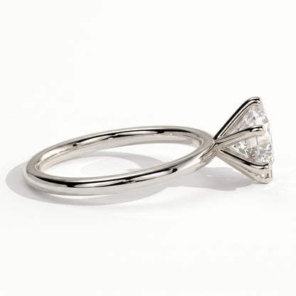 A rose gold engagement ring featuring a large round brilliant-cut diamond, shown in a three-quarter side view on a clean white background. 
