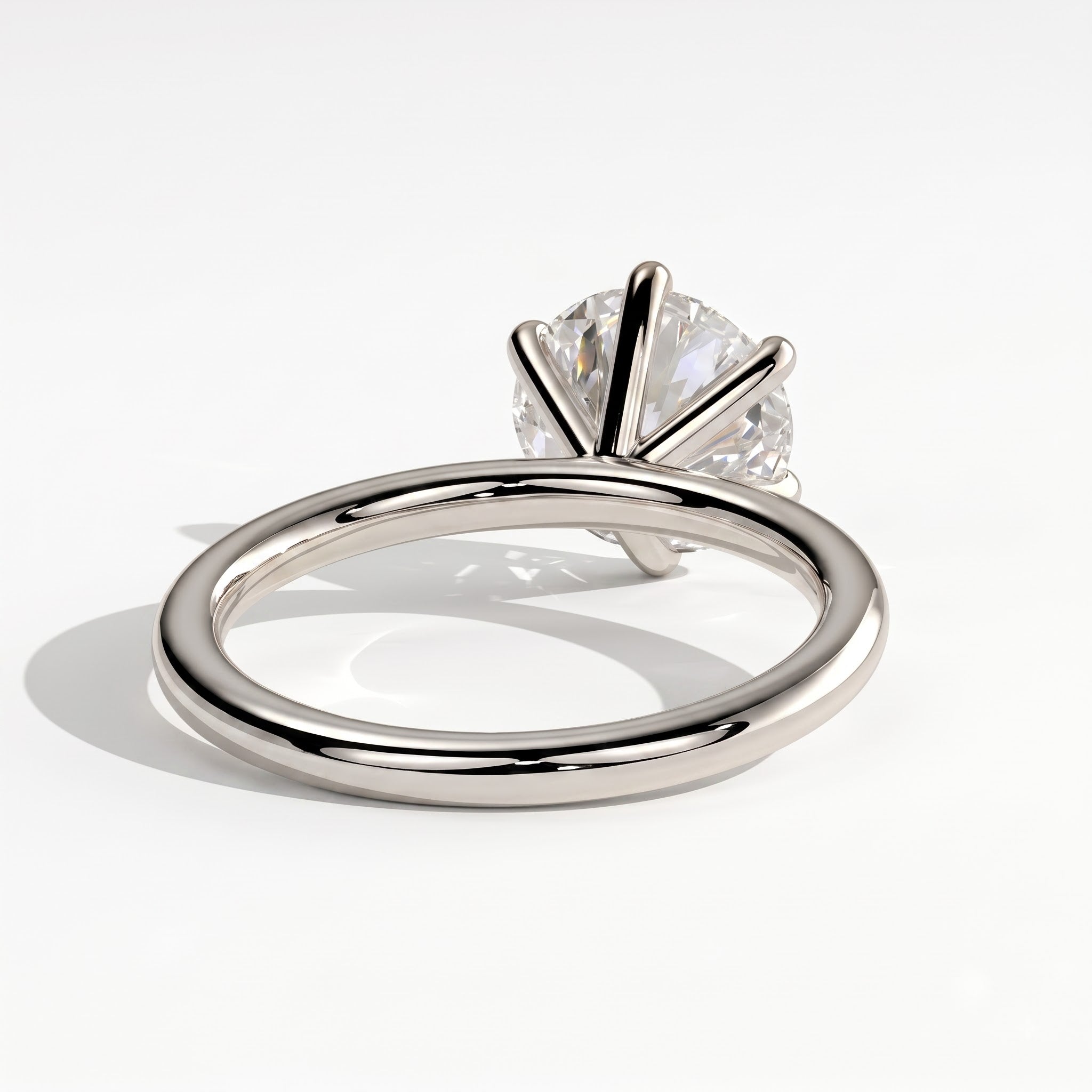 A polished silver-tone solitaire ring with a round brilliant-cut clear gemstone in a prong setting, shown on a clean white background with a soft shadow. 