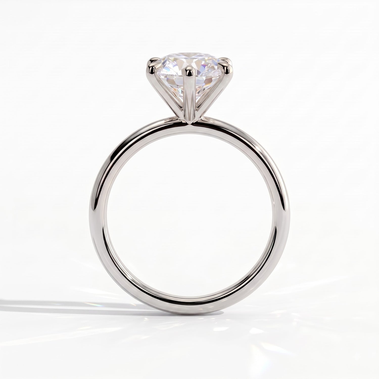 A classic solitaire engagement ring featuring a round brilliant-cut diamond set in a polished white gold or platinum band, shown against a clean white background. 