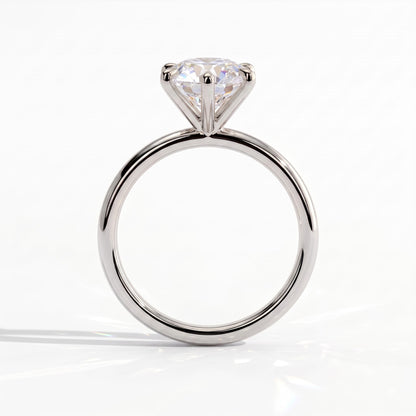 A classic solitaire engagement ring featuring a round brilliant-cut diamond set in a polished platinum band, shown against a clean white background. 