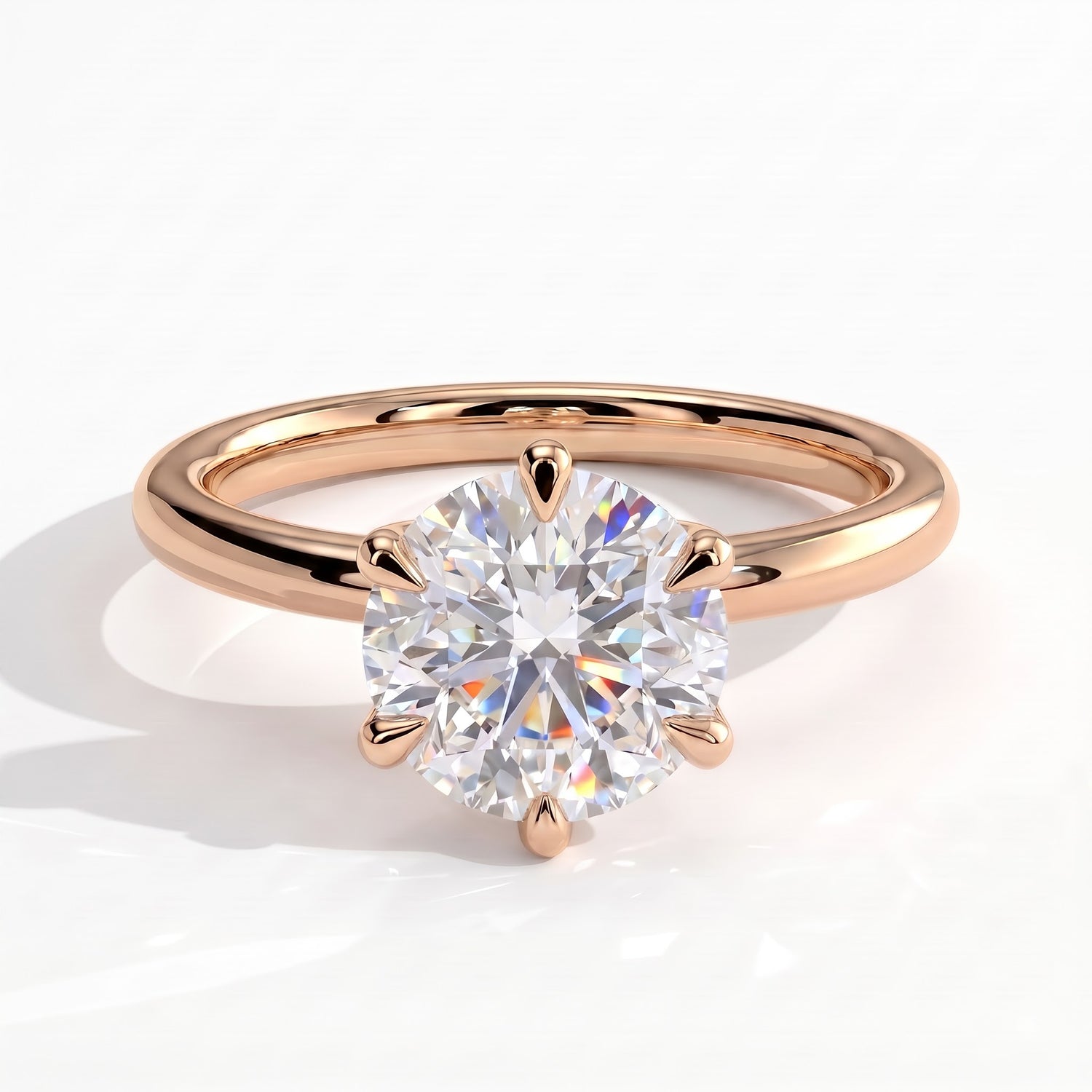A rose gold solitaire engagement ring with a round brilliant-cut diamond set in a six-prong setting, shown on a clean white background with a soft shadow. 