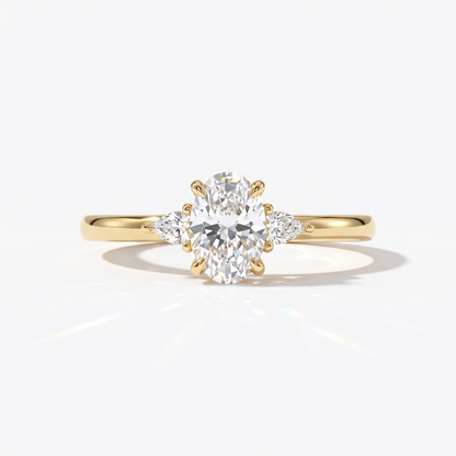Oval cut lab-grown diamond three-stone engagement ring with pear side stones in 14K (585) yellow gold, front view 