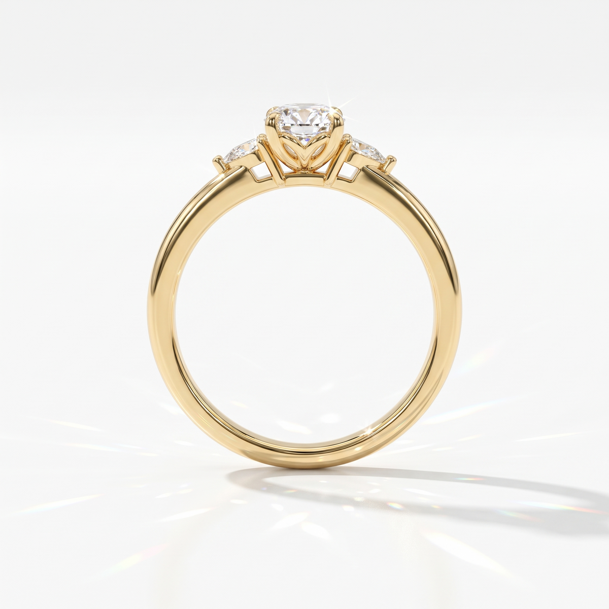 Oval cut lab-grown diamond three-stone engagement ring with pear side stones in 18K (750) yellow gold, upright profile view 