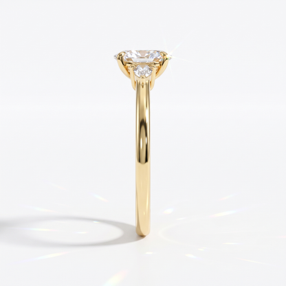 Oval cut lab-grown diamond three-stone engagement ring with pear side stones in 14K (585) yellow gold, side view 