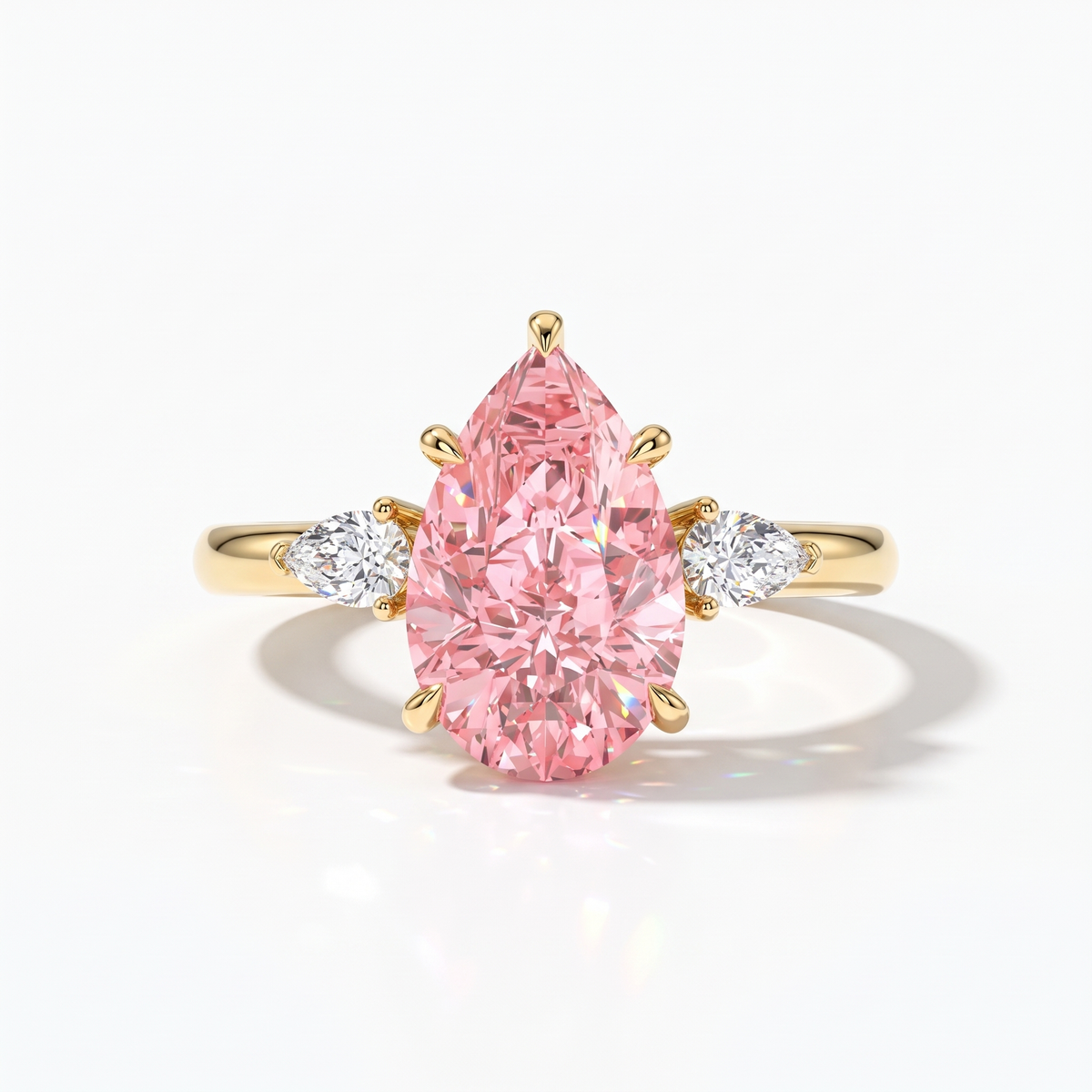 Fancy Vivid Pink pear cut lab-grown diamond three-stone ring with pear side diamonds in 14K (585) yellow gold, front view 