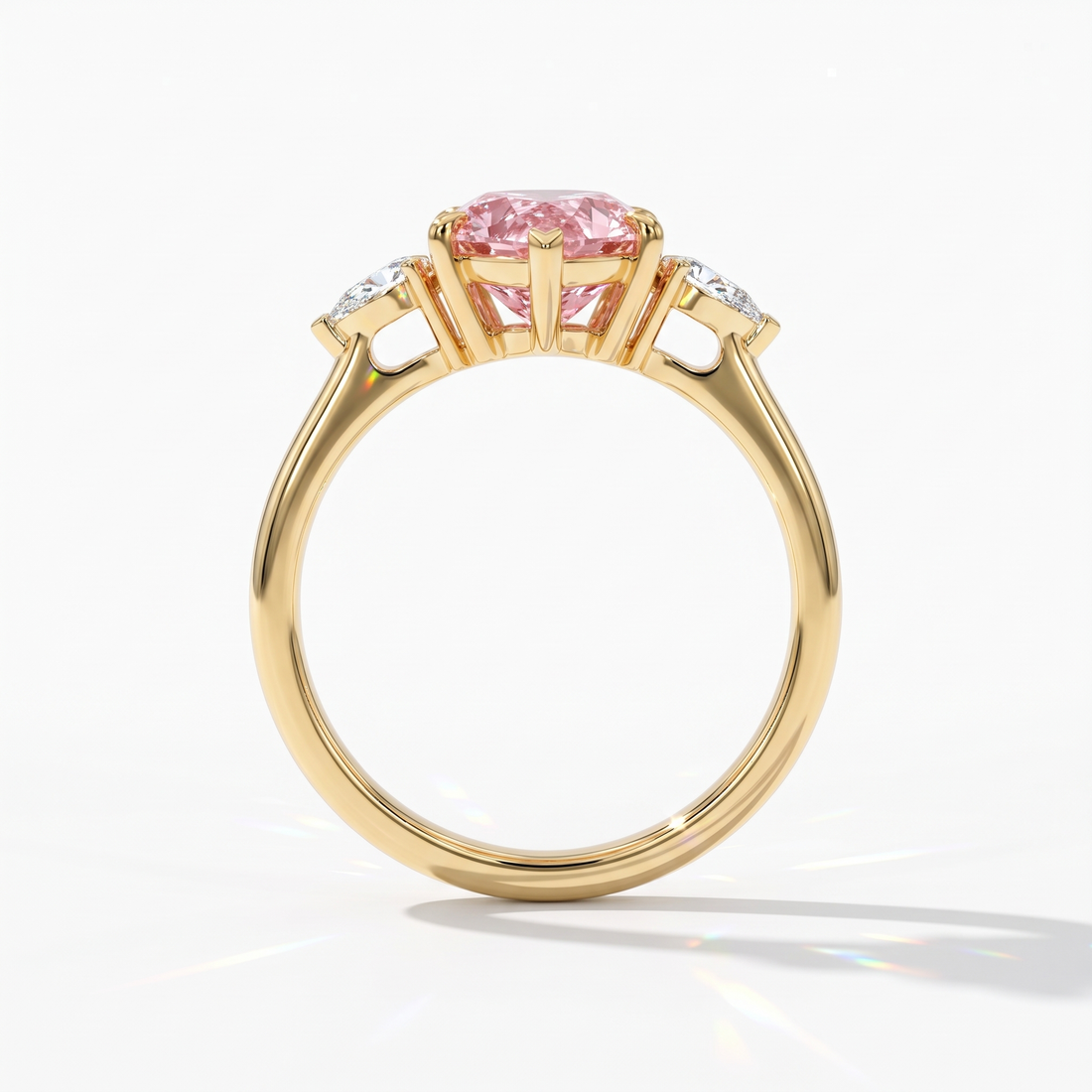 Fancy Vivid Pink pear cut lab-grown diamond three-stone ring with pear side diamonds in 14K (585) yellow gold, upright profile view 