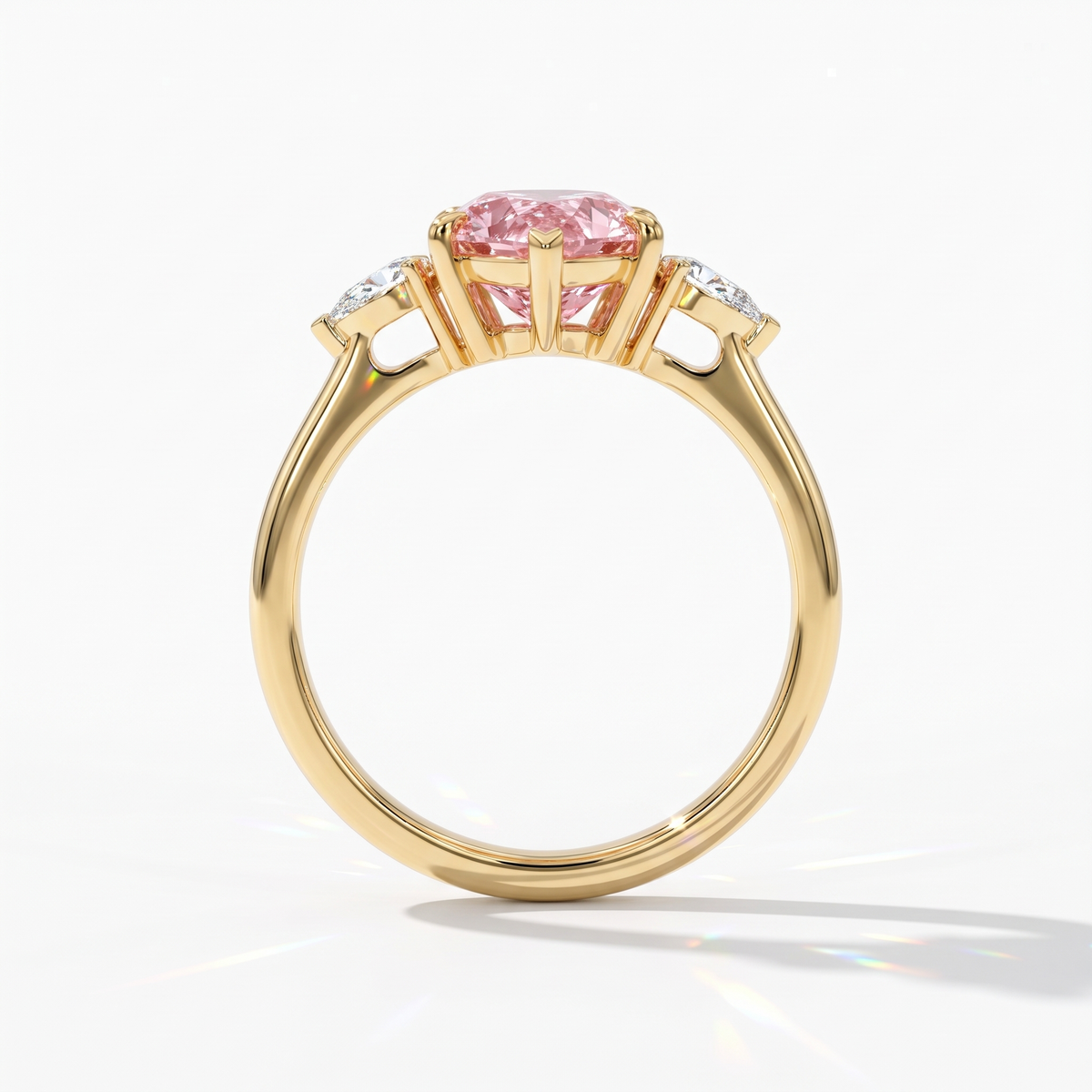Fancy Vivid Pink pear cut lab-grown diamond three-stone ring with pear side diamonds in 14K (585) yellow gold, upright profile view 