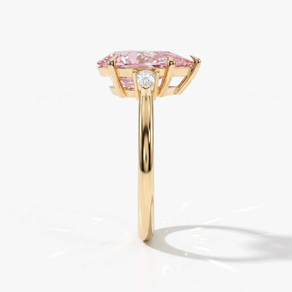 Fancy Vivid Pink pear cut lab-grown diamond three-stone ring with pear side diamonds in 14K (585) yellow gold, side view 