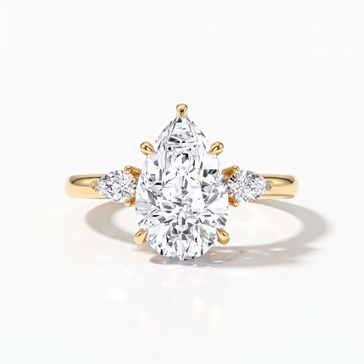 Pear cut lab-grown diamond three-stone engagement ring with pear side stones in 14K (585) yellow gold, front view 