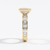 Emerald cut lab-grown diamond bezel engagement ring with channel-set baguette diamonds in 18K (750) yellow gold, side view 