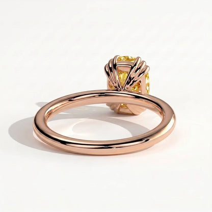 Fancy Vivid Yellow elongated cushion lab-grown diamond solitaire engagement ring with triple claw prongs in 18K (750) rose gold, detail view of the triple claws 