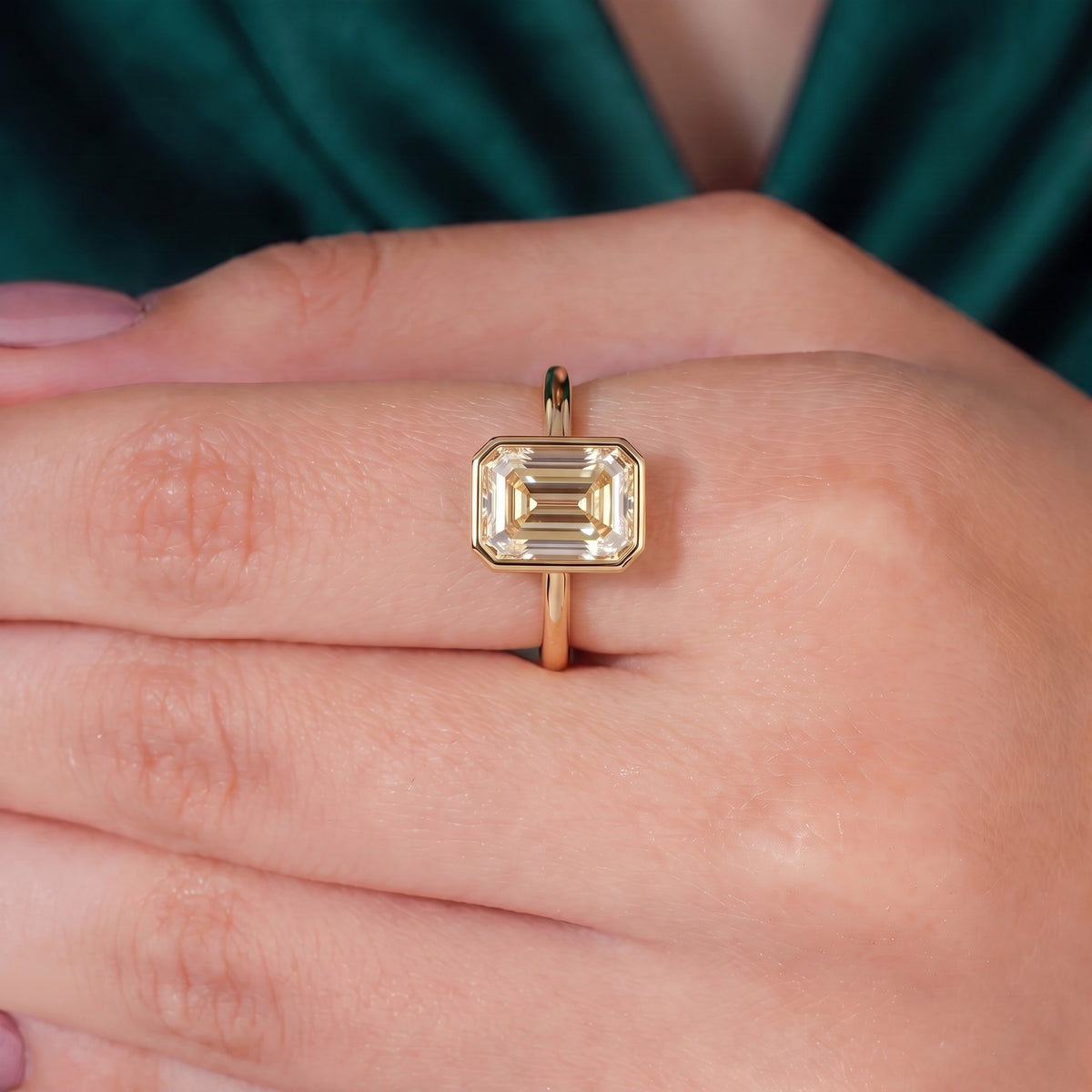 Fancy Intense Yellow emerald cut lab-grown diamond bezel ring in 18K (750) white gold, worn on finger, on-hand top view 