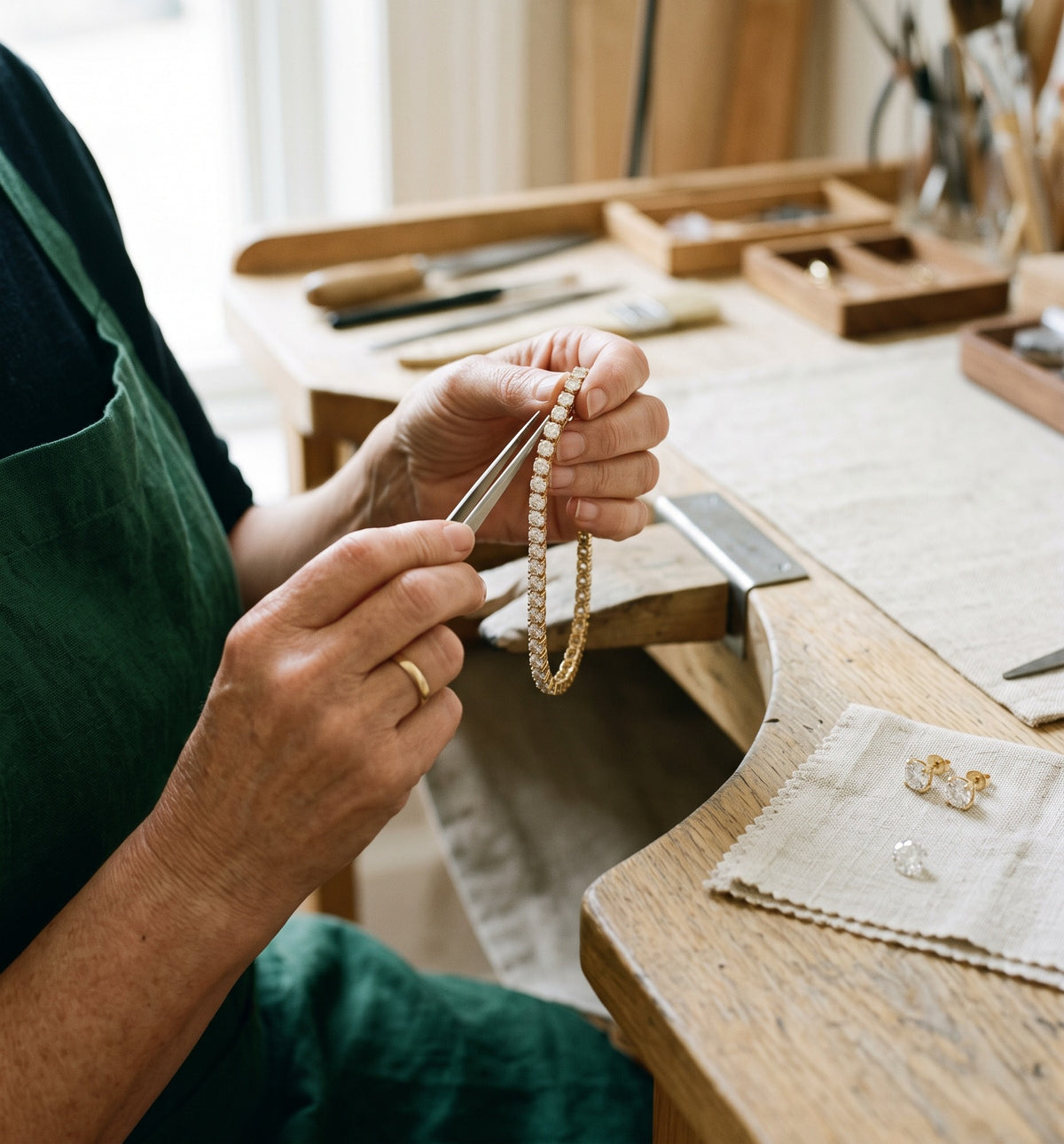 Goldsmith checking the setting of a lab-grown diamond tennis bracelet at the workbench