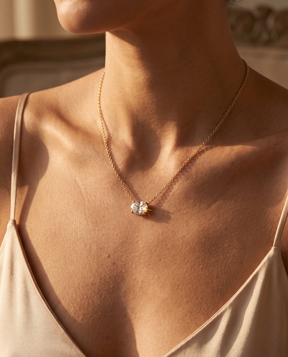 Oval lab-grown diamond solitaire pendant necklace in yellow gold worn with a silk dress