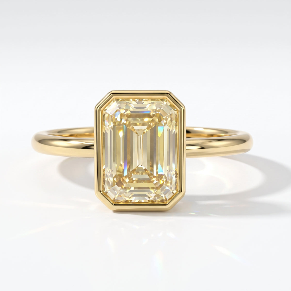 Fancy Intense Yellow emerald cut lab-grown diamond bezel ring in 14K (585) yellow gold, top view 