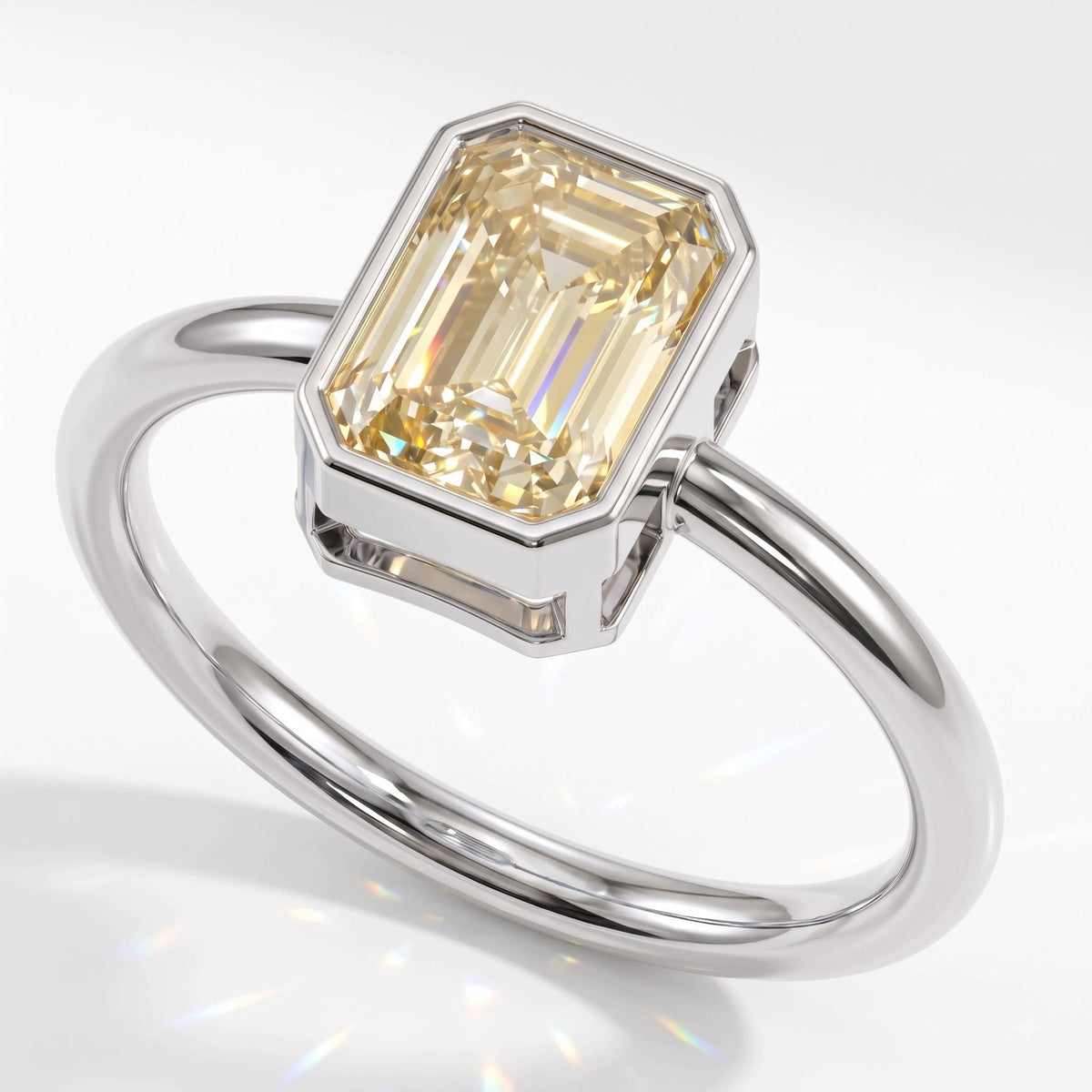 Fancy Intense Yellow emerald cut lab-grown diamond bezel ring in 14K (585) white gold, angled view 