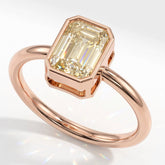 Fancy Intense Yellow emerald cut lab-grown diamond bezel ring in 18K (750) rose gold, angled view 