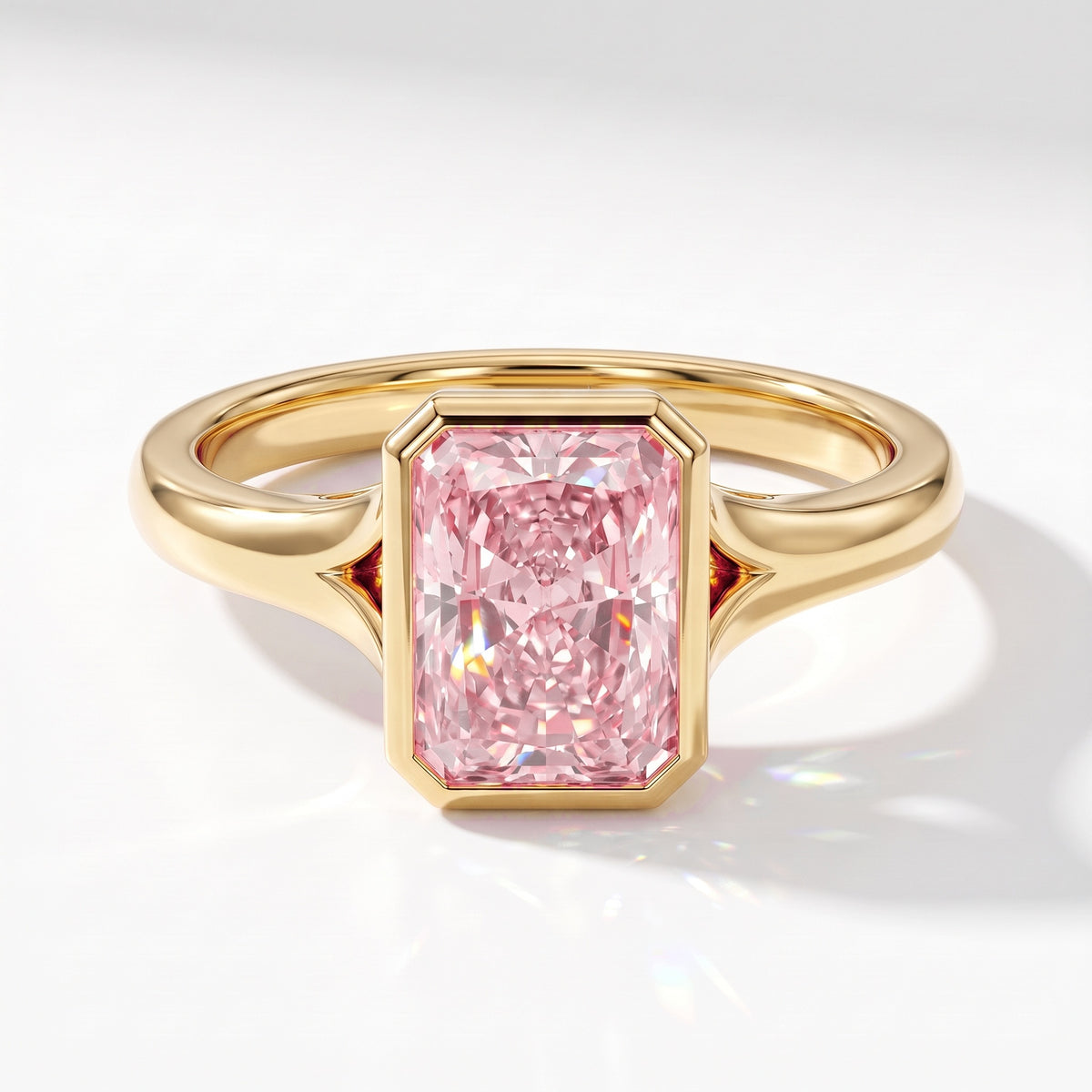 Fancy Vivid Pink radiant lab-grown diamond bezel ring in 18K (750) yellow gold, angled top view 
