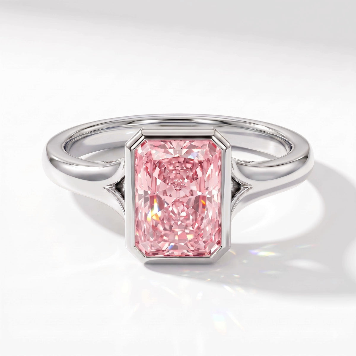 Fancy Vivid Pink radiant lab-grown diamond bezel ring in 950 platinum, angled top view 