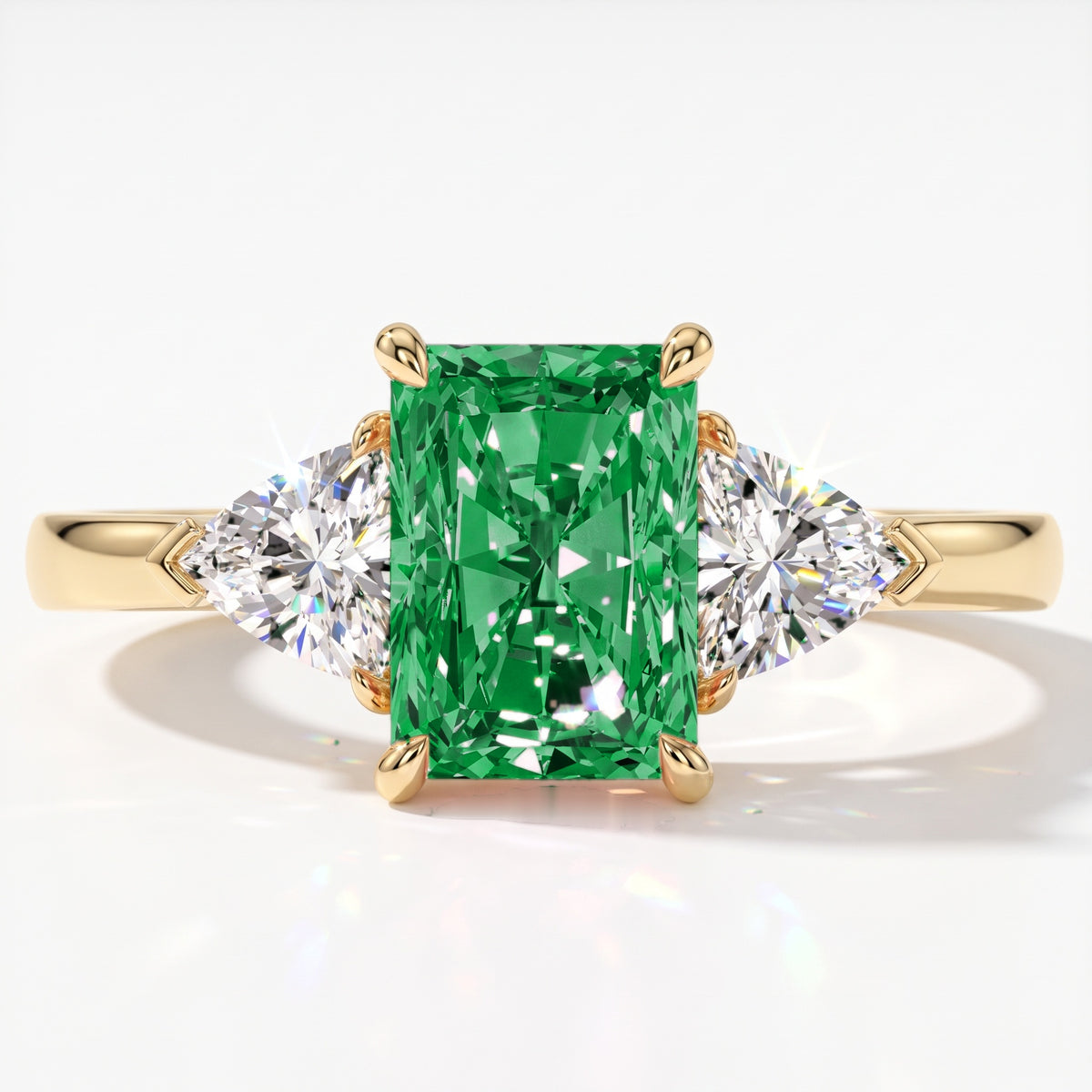 Fancy Vivid Green radiant lab-grown diamond three-stone ring with trillion side diamonds in 14K (585) yellow gold, top view 