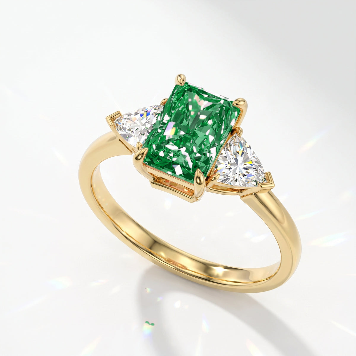Fancy Vivid Green radiant lab-grown diamond three-stone ring with trillion side diamonds in 14K (585) yellow gold, angled view 
