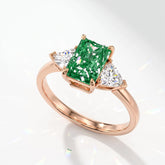 Fancy Vivid Green radiant lab-grown diamond three-stone ring with trillion side diamonds in 14K (585) rose gold, angled view 