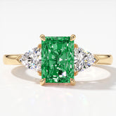 Fancy Vivid Green radiant lab-grown diamond three-stone ring with trillion side diamonds in 18K (750) yellow gold, top view 