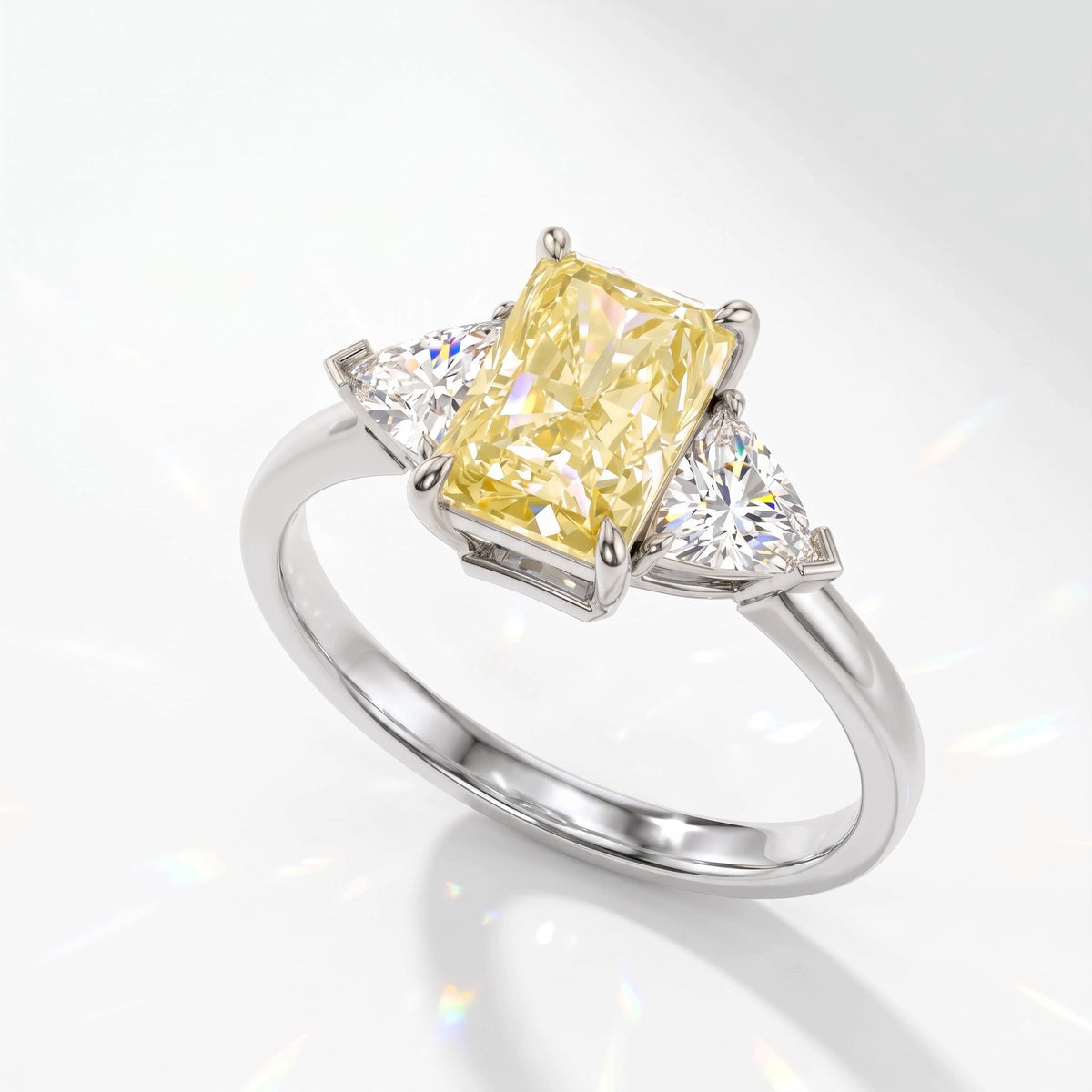 Fancy Vivid Yellow radiant lab-grown diamond three-stone ring with trillion side diamonds in 14K (585) white gold, angled view 