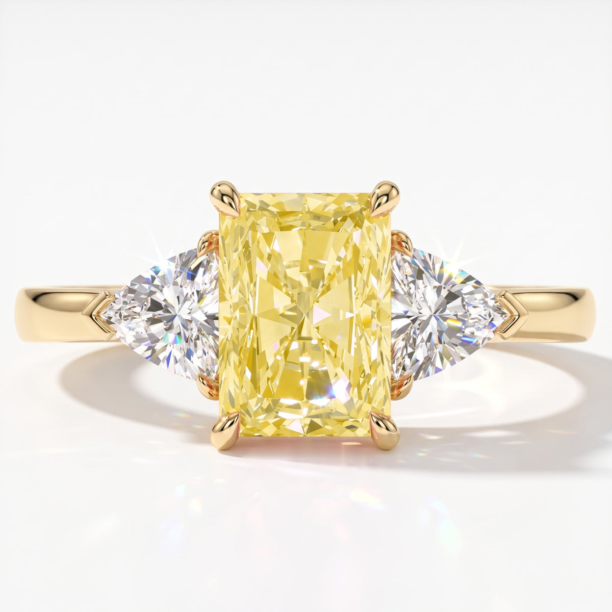 Fancy Vivid Yellow radiant lab-grown diamond three-stone ring with trillion side diamonds in 18K (750) yellow gold, top view 