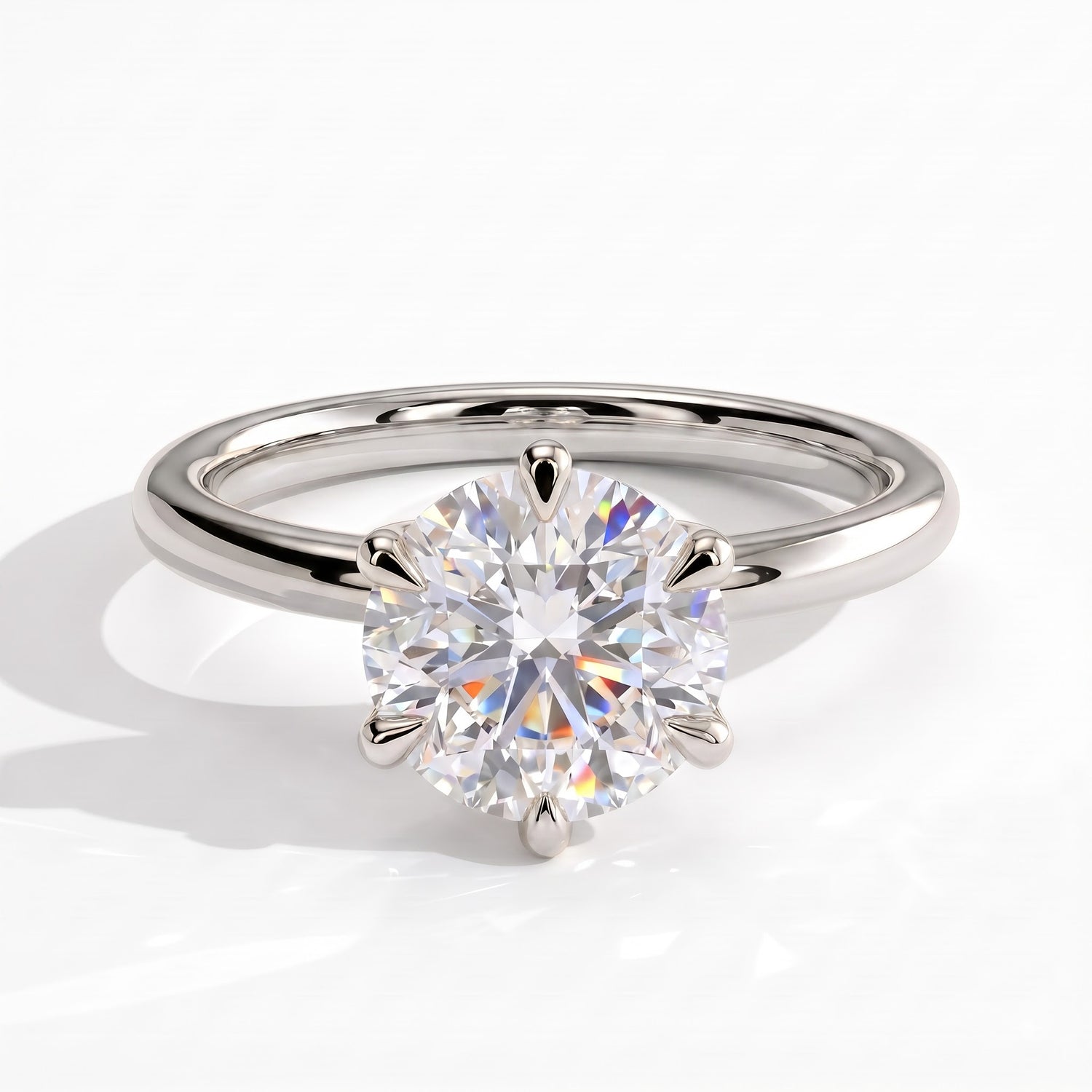 A classic solitaire engagement ring featuring a round brilliant-cut diamond set in a polished white platinum band, shown on a clean white background with a soft shadow. 