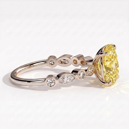Fancy Vivid Yellow oval lab-grown diamond engagement ring with bezel-set pear and round shoulder accents in 950 platinum, detail view of the bezel-set shoulder accents 