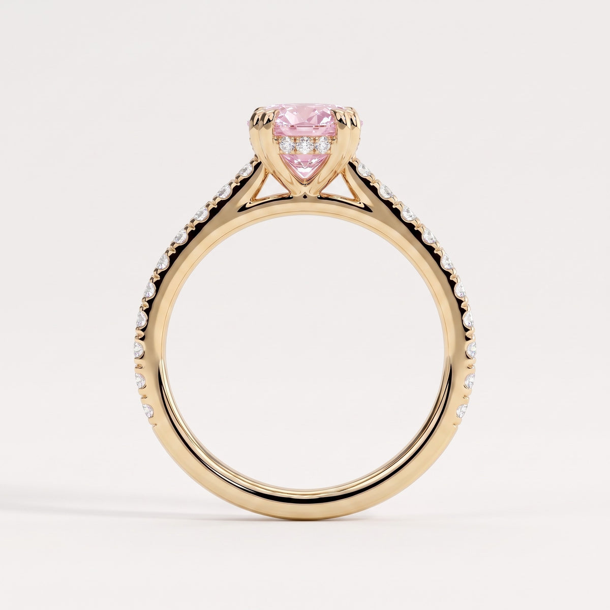 Fancy Vivid Pink oval lab-grown diamond double claw engagement ring with pavé band and hidden halo in 18K (750) yellow gold, side profile showing the cathedral setting 