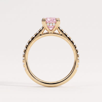 Fancy Vivid Pink oval lab-grown diamond double claw engagement ring with pavé band and hidden halo in 18K (750) yellow gold, side profile showing the cathedral setting 
